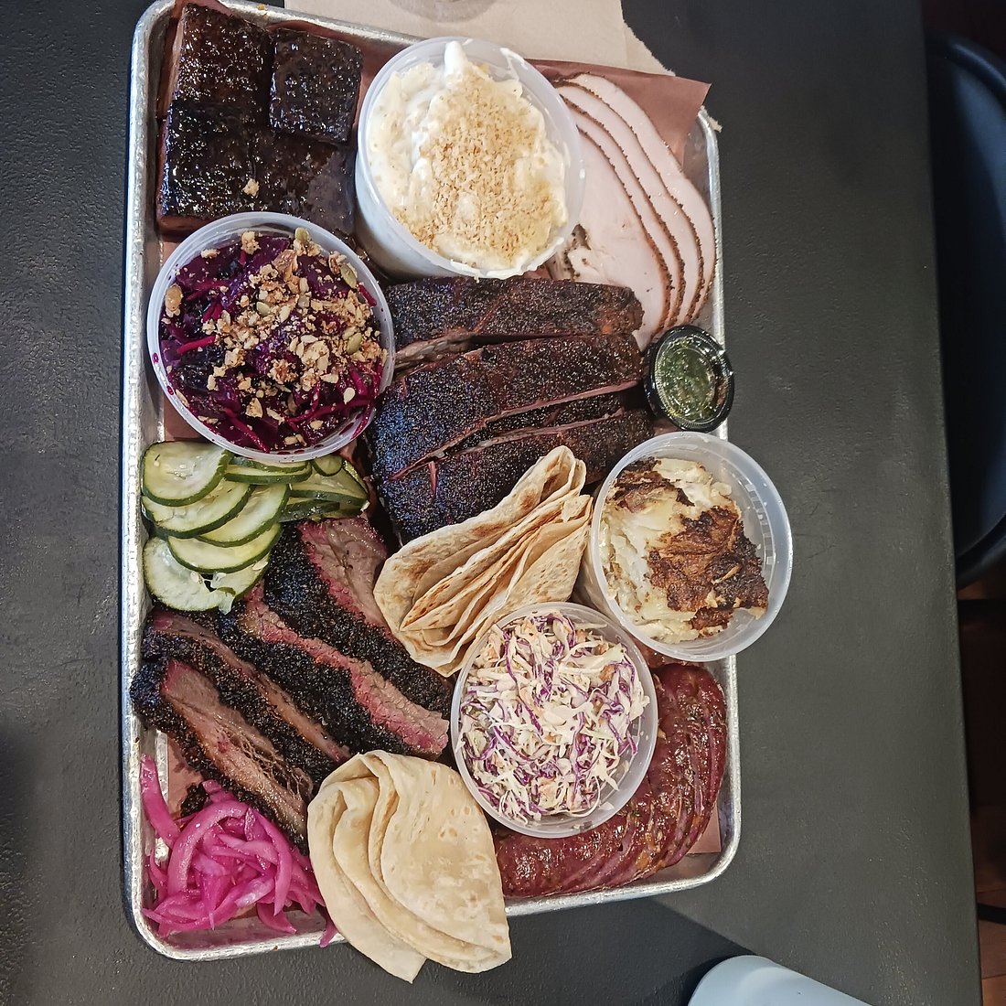 Interstellar BBQ signature dishes Brisket, Pork Belly Burnt Ends, Jalapeño Popper Sausage, Smoked Scalloped Potatoes